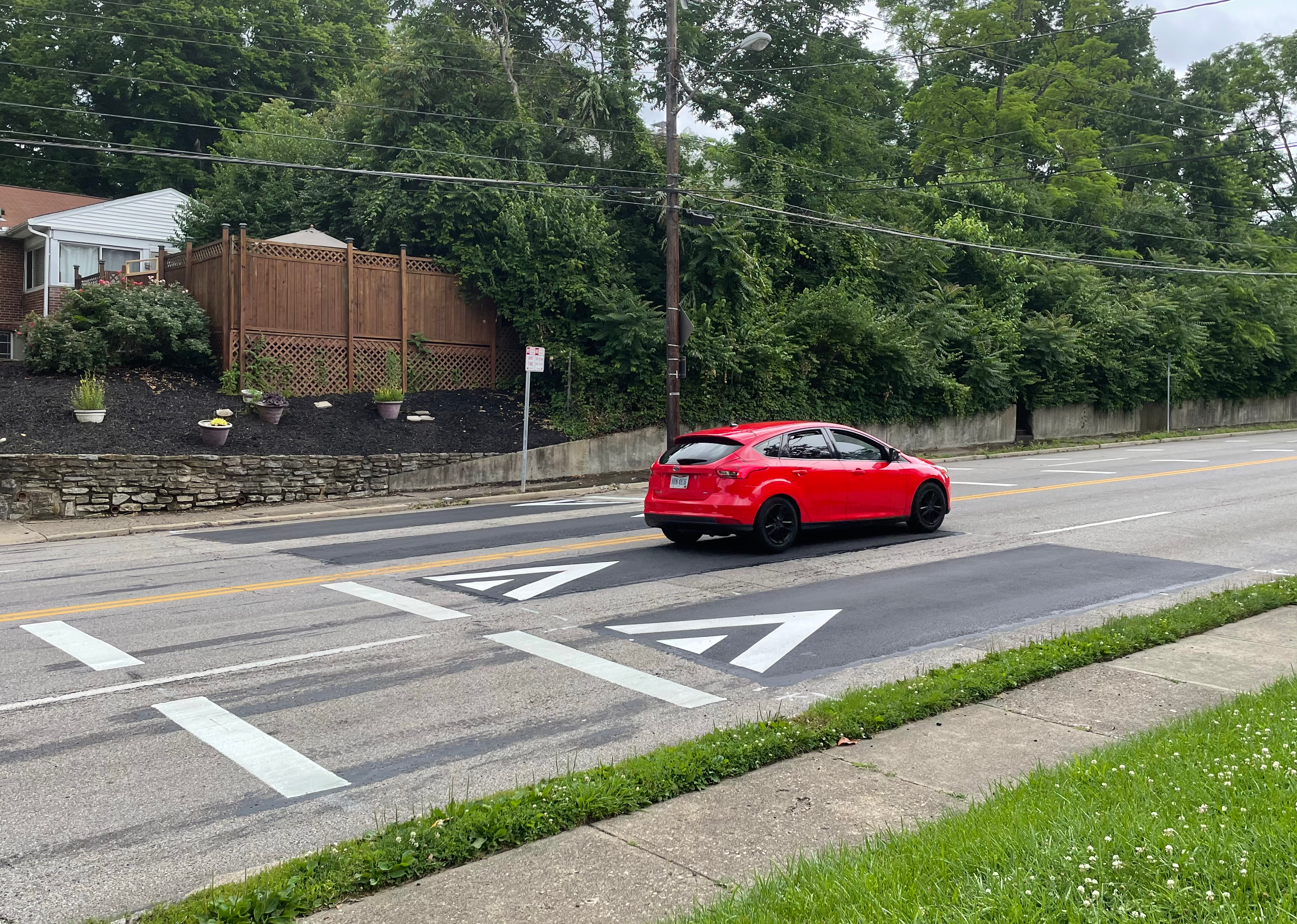 A car driving over a speed cushion.